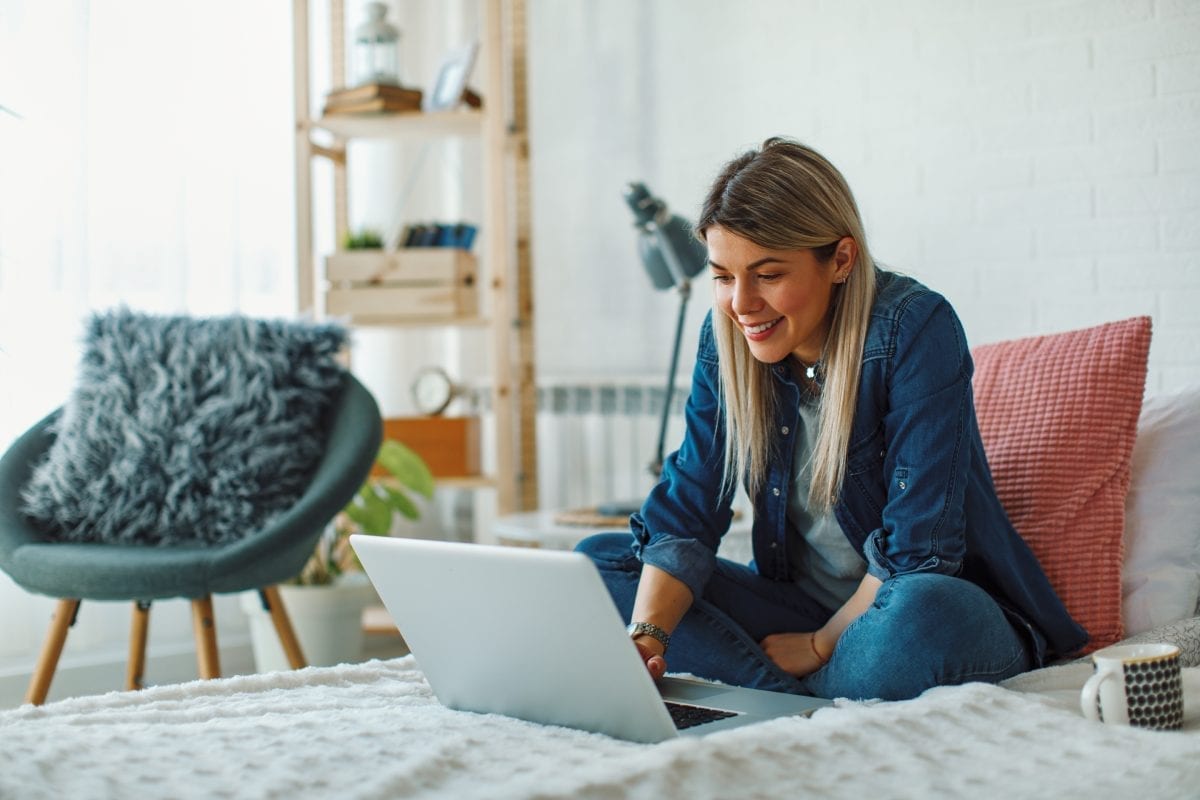 Young Woman in Modern Apartment using Laptop