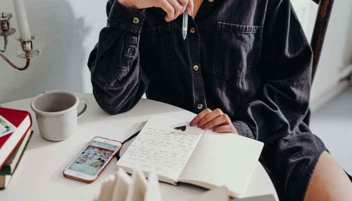 Women writing down her goals for the new year on journal 