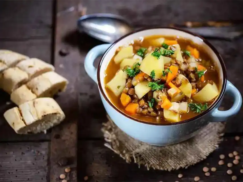 a bowl of soup with vegetables and a spoon