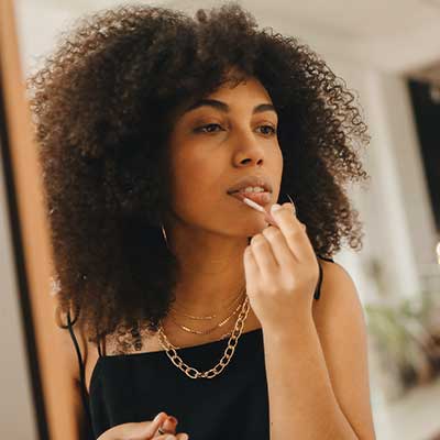 Lady applying lip gloss.