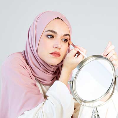 Woman applying eye products.