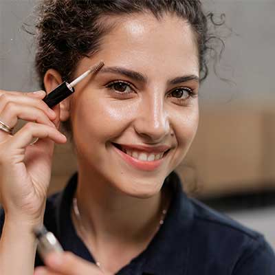 Woman applying brow gel.