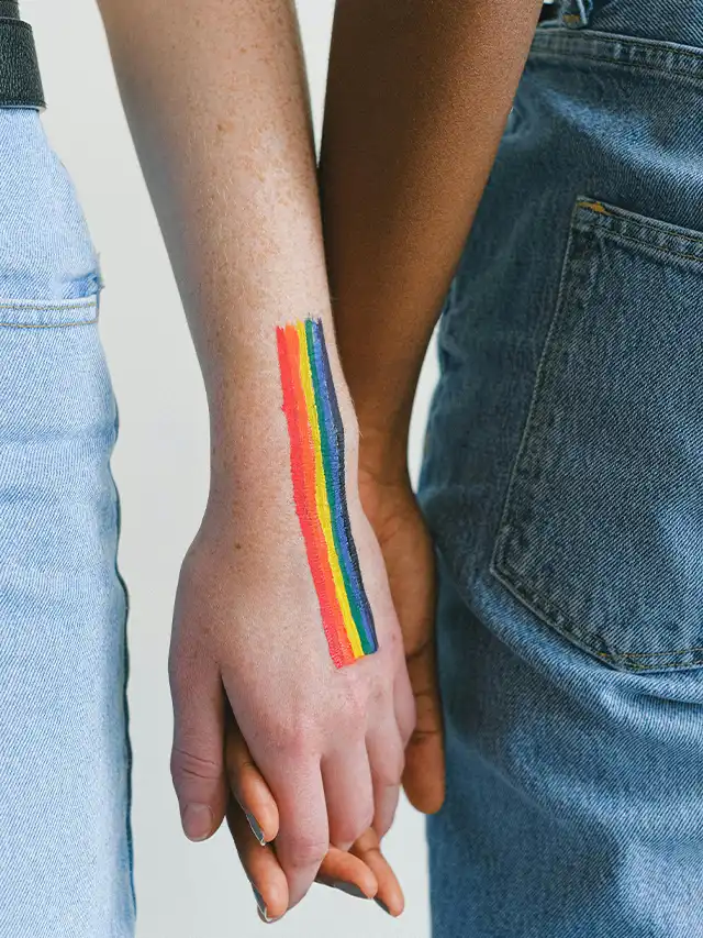 a person's hand with a rainbow painted on it