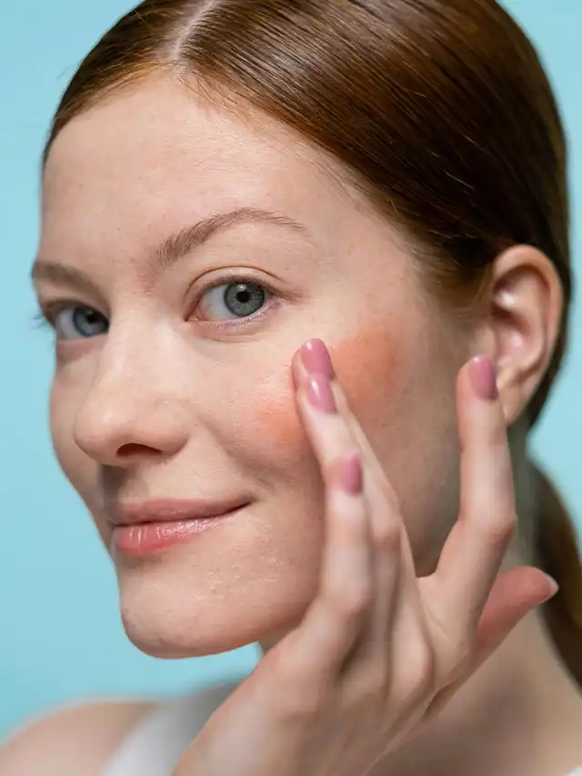 a woman with red hair touching her face