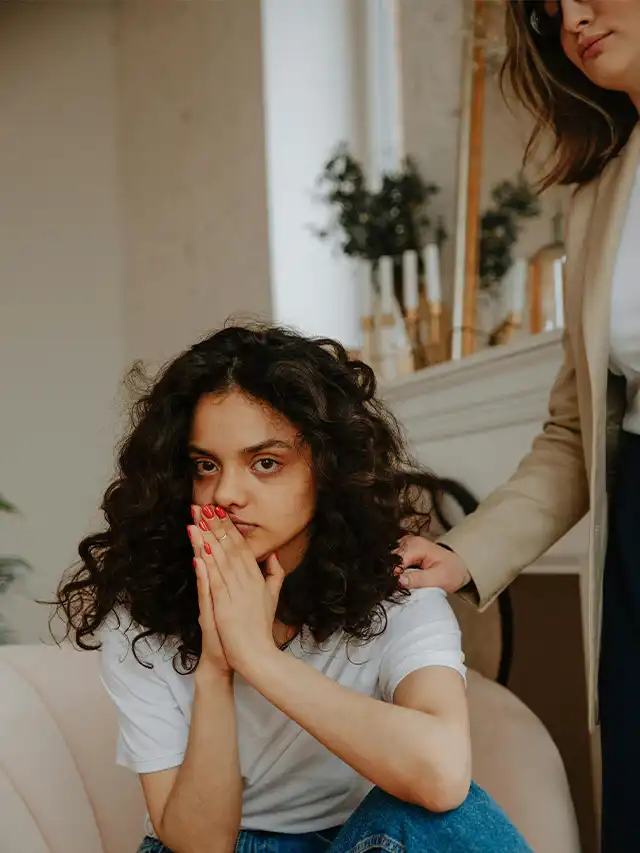 a woman holding her hands together to her face