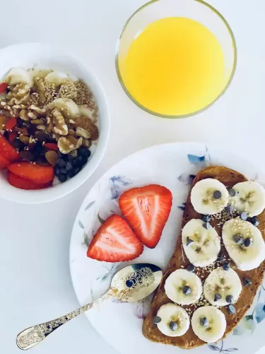 a plate of food with fruit and a glass of juice