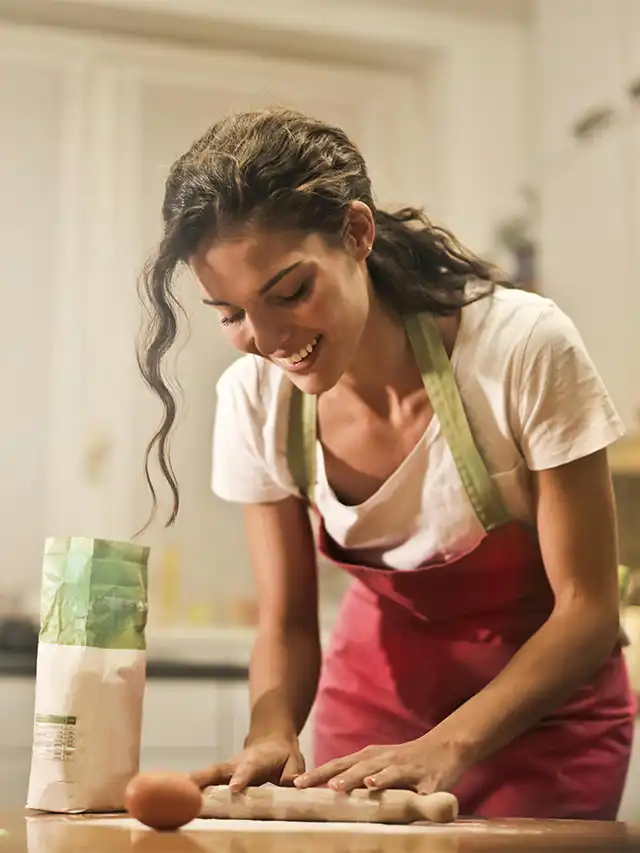 a woman in a red apron cutting food