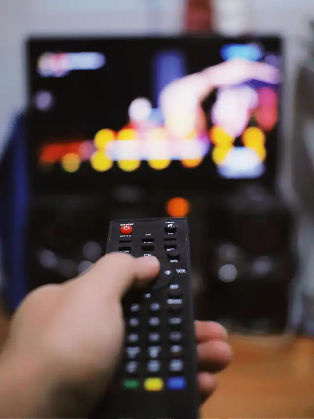 a hand holding a remote control