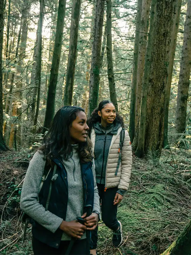 two women standing in a forest