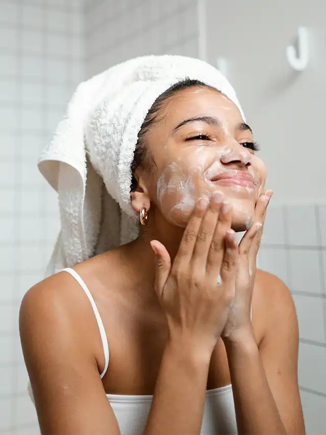 a woman applying a cream on her face