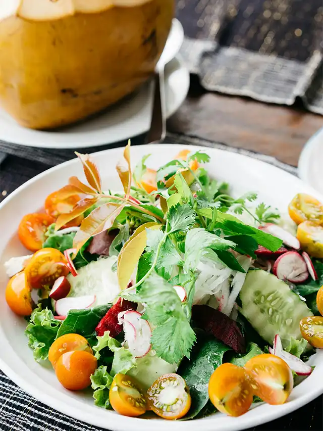 a plate of salad with vegetables and greens