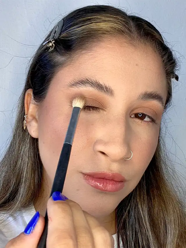 a woman applying makeup with a brush