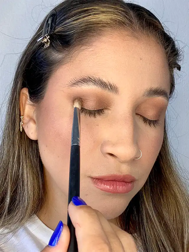 a woman applying makeup on her eyes