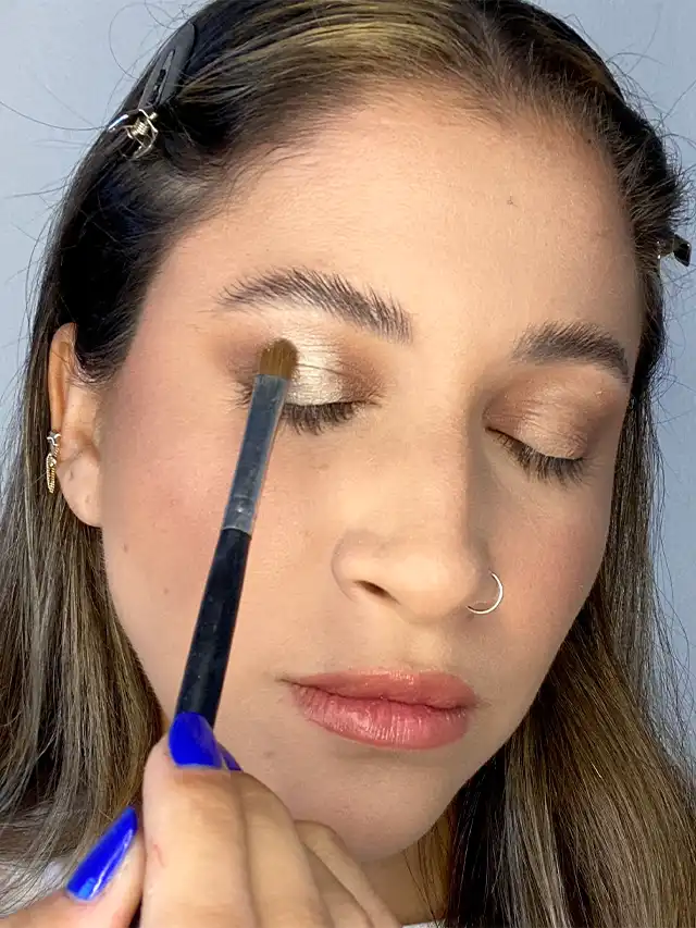 a woman applying makeup with a brush