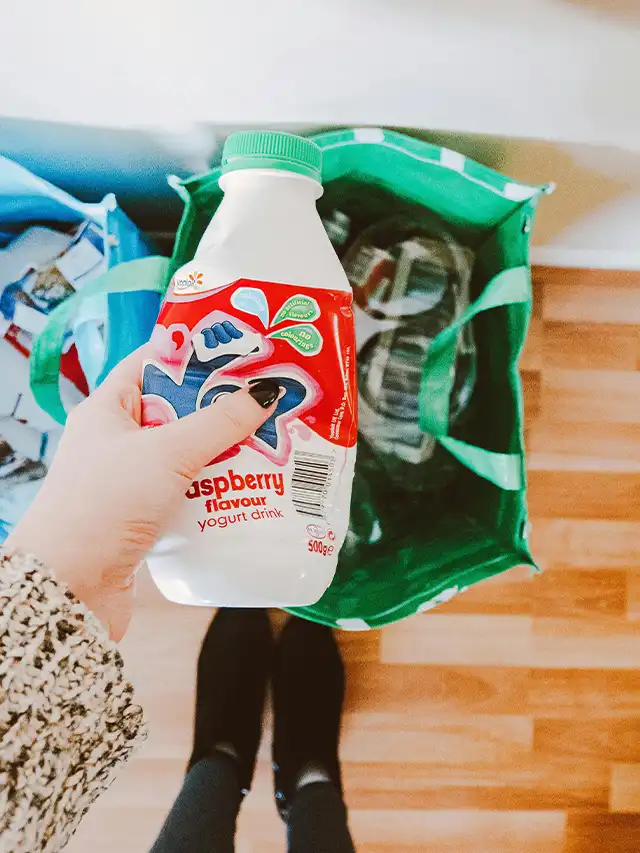 a hand holding a bottle of yogurt