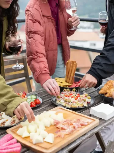 a group of people standing around a table with food