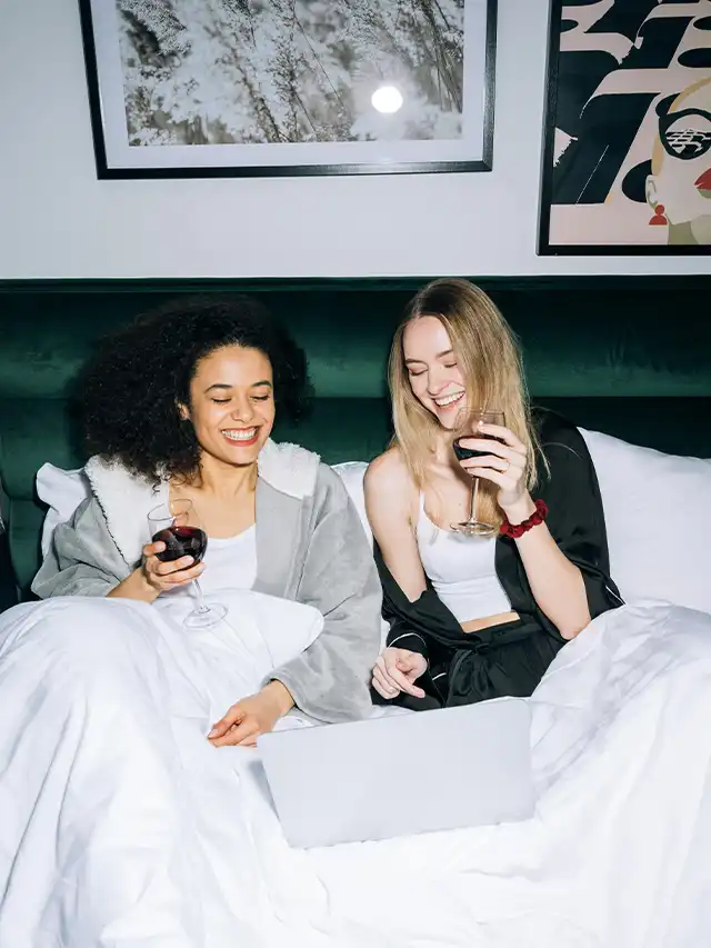 two women sitting on a bed