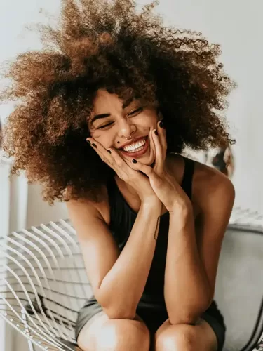 a woman with curly hair and a nose ring