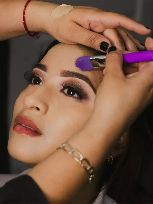 a woman getting her makeup done