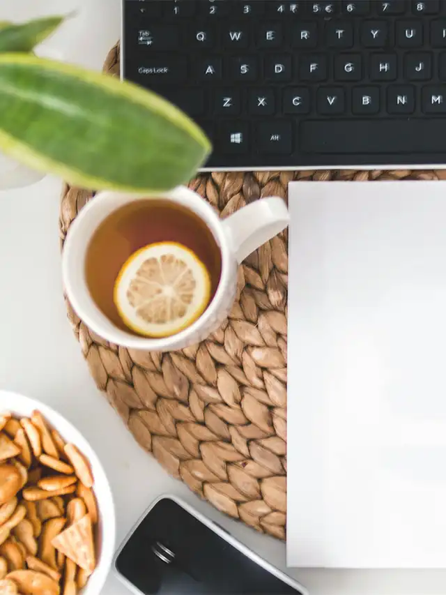 a cup of tea with lemon and a slice of lemon on a table