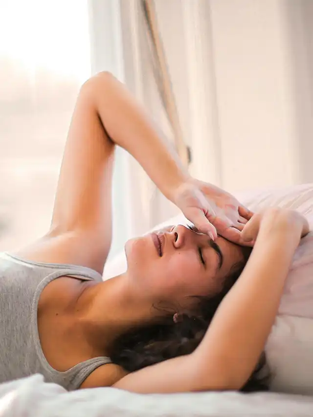 a woman lying on a bed with her eyes closed